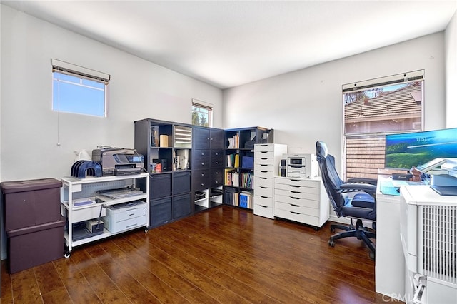 home office featuring dark wood-type flooring and a healthy amount of sunlight