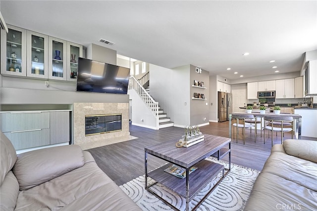 living room with wood-type flooring and a high end fireplace