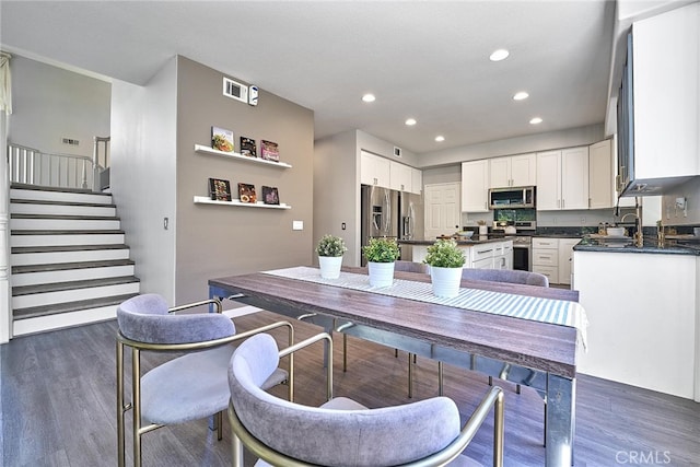 kitchen featuring white cabinetry, appliances with stainless steel finishes, and dark hardwood / wood-style flooring