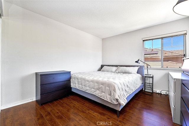 bedroom with dark hardwood / wood-style flooring