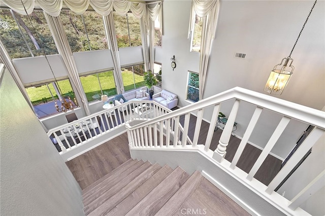 staircase featuring a chandelier and hardwood / wood-style floors