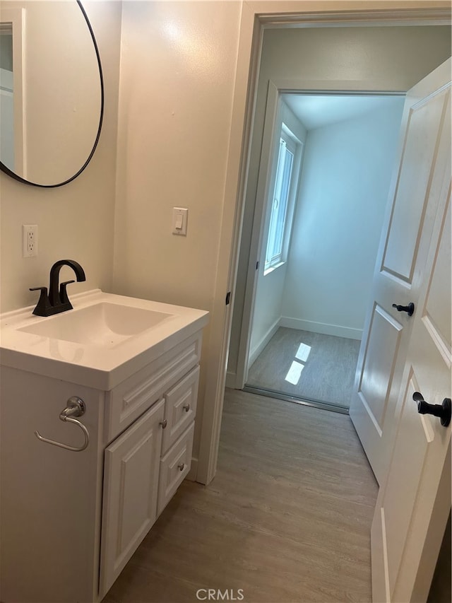 bathroom featuring wood finished floors, vanity, and baseboards