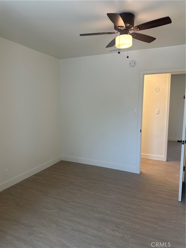 unfurnished room featuring ceiling fan, baseboards, and wood finished floors