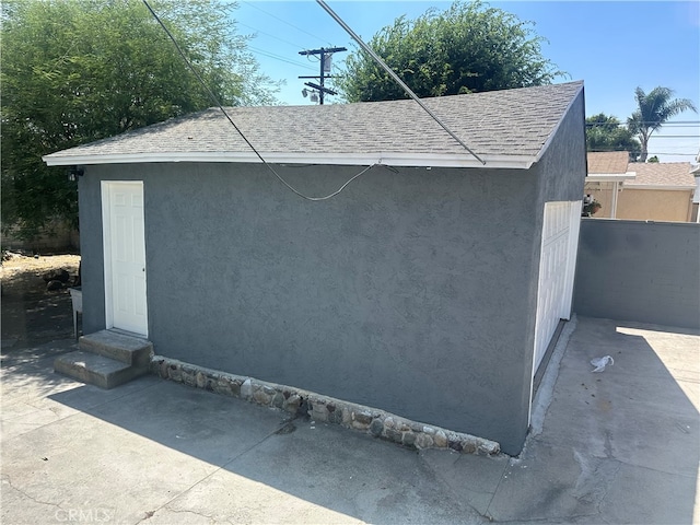 view of outbuilding with entry steps and fence