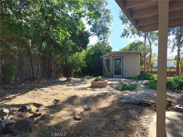 view of yard with an outdoor structure and an outdoor fire pit