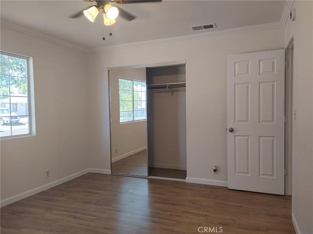 unfurnished bedroom with dark hardwood / wood-style floors, a closet, and multiple windows