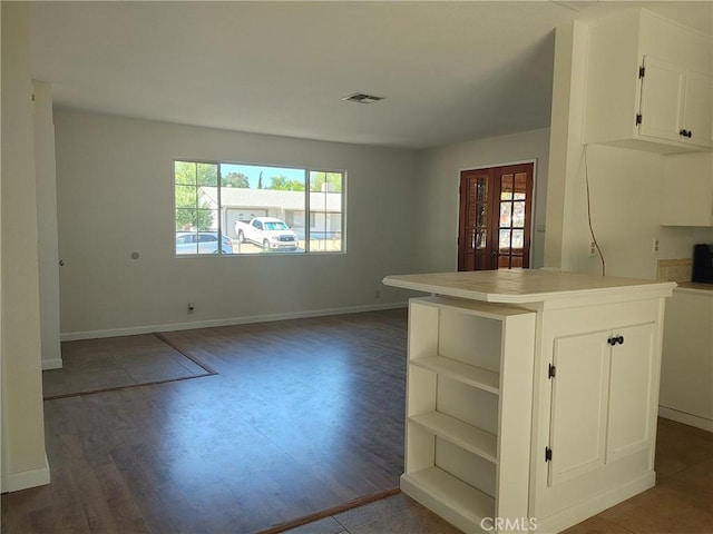 kitchen featuring white cabinets, a center island, dark hardwood / wood-style floors, and a wealth of natural light