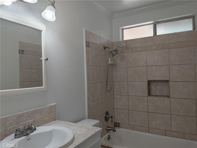 full bathroom with vanity, toilet, ornamental molding, and tiled shower / bath