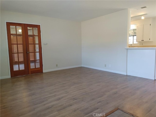 unfurnished room with hardwood / wood-style floors and french doors