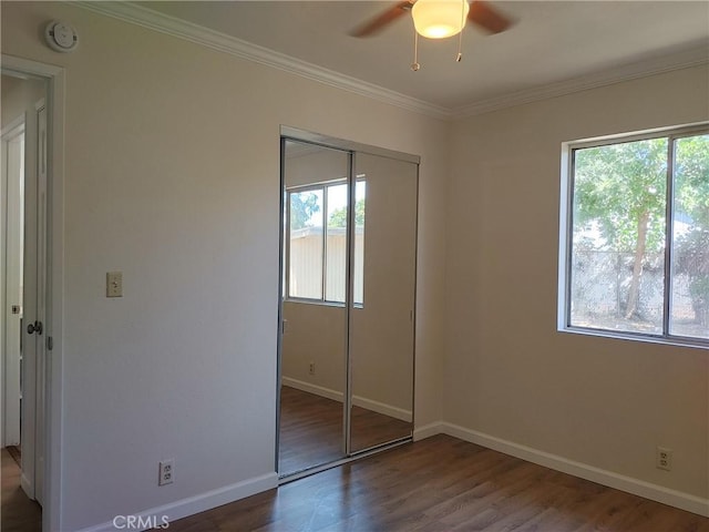 unfurnished bedroom with multiple windows, a closet, and hardwood / wood-style flooring