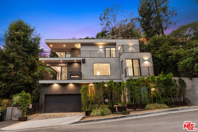 contemporary home featuring a balcony and a garage