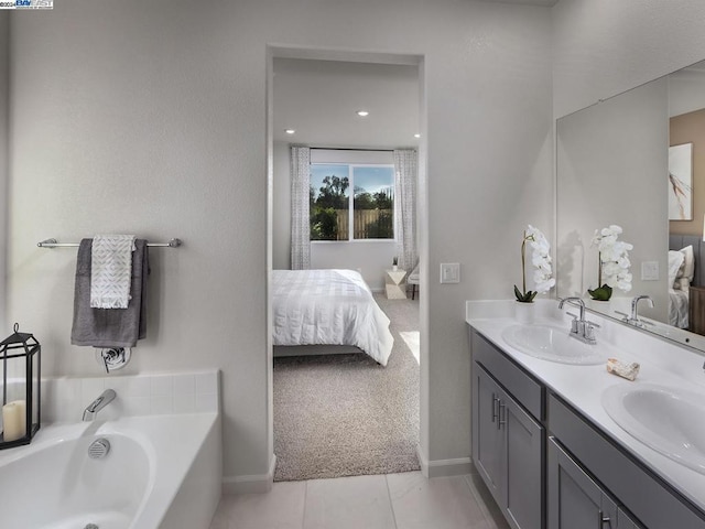 bathroom with tile patterned flooring, vanity, and a bathtub