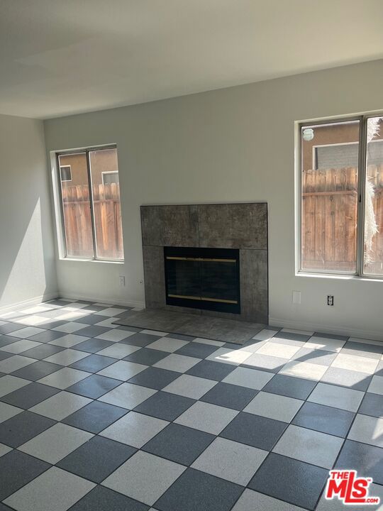 unfurnished living room featuring a tile fireplace