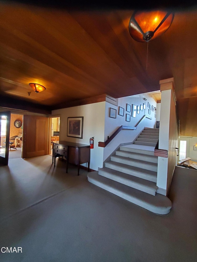 stairway with wood ceiling, carpet flooring, and a wealth of natural light