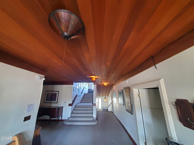 stairway with concrete flooring and wooden ceiling