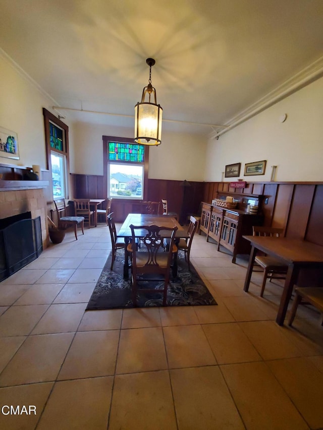 dining room featuring a tile fireplace and light tile patterned flooring