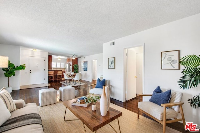 living room with hardwood / wood-style floors, a textured ceiling, and ceiling fan