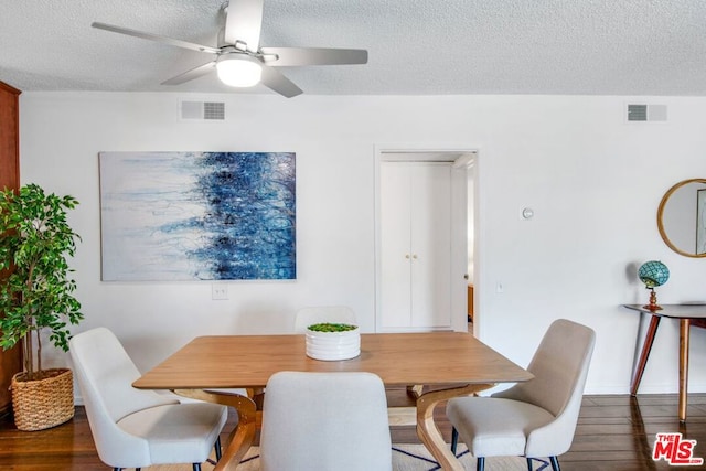 dining space featuring a textured ceiling, dark hardwood / wood-style flooring, and ceiling fan