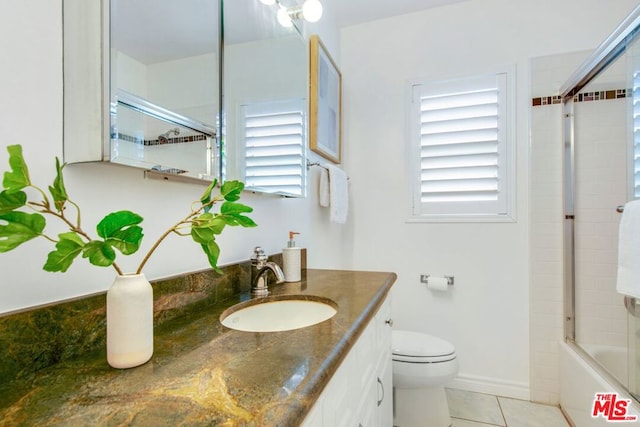 full bathroom with tile patterned flooring, vanity, toilet, and shower / bath combination with glass door