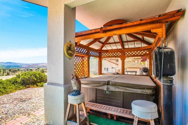 view of patio / terrace featuring a mountain view, a gazebo, and a hot tub