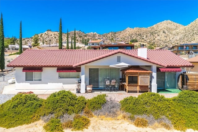 view of front of property featuring a mountain view and a patio area