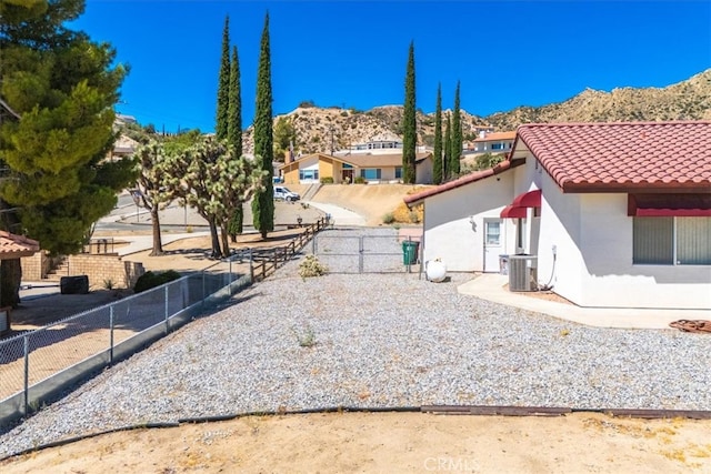 exterior space with a patio, a mountain view, and central AC