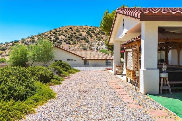 view of property exterior with a mountain view and a patio area