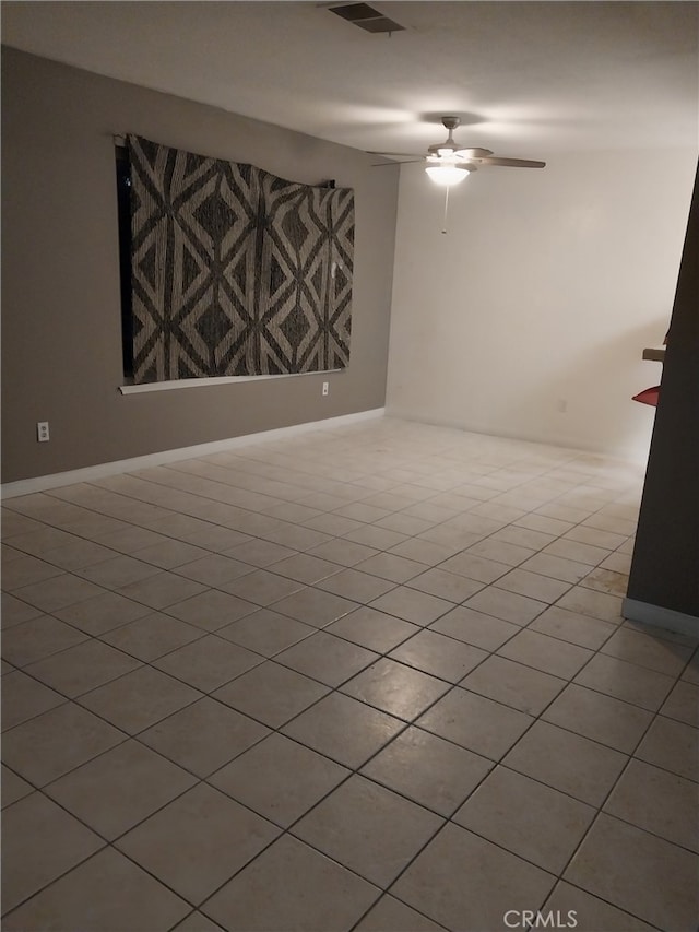 tiled spare room featuring ceiling fan