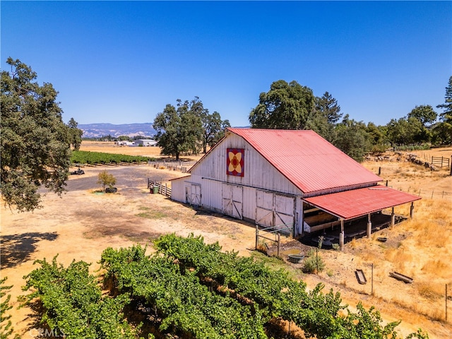 exterior space featuring a mountain view, an outdoor structure, and a rural view