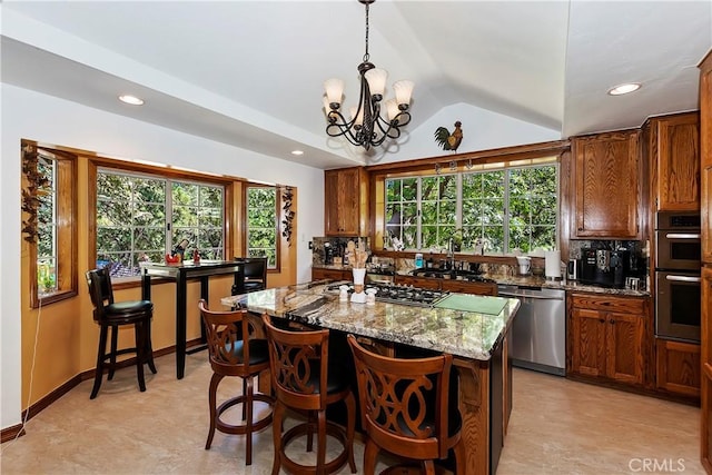 30184 Sky Line Dr, Running Springs, CA 92382 - kitchen featuring stainless steel appliances, lofted ceiling, light stone counters, a kitchen island, and a chandelier