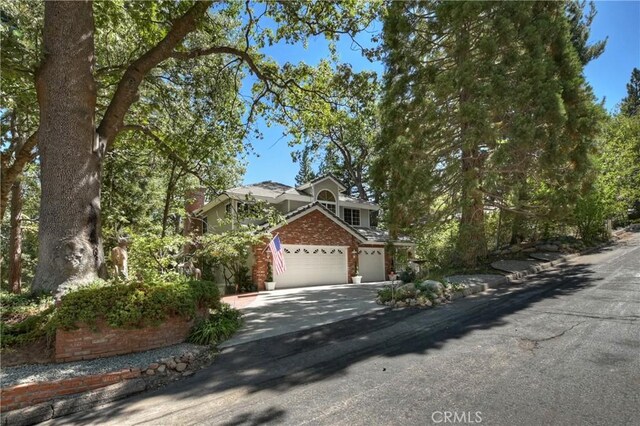 30184 Sky Line Dr, Running Springs, CA 92382 - view of front facade featuring driveway, brick siding, and a garage