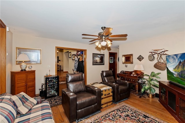 living room featuring light wood-type flooring, wine cooler, and ceiling fan