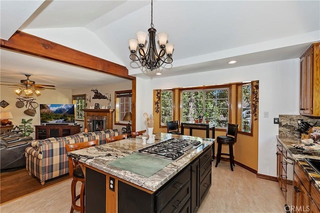 30184 Sky Line Dr, Running Springs, CA 92382 - kitchen with open floor plan, stainless steel gas stovetop, vaulted ceiling, light stone counters, and a chandelier