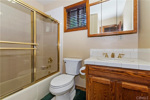 full bathroom featuring vanity, toilet, and bath / shower combo with glass door