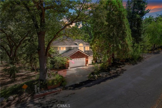 30184 Sky Line Dr, Running Springs, CA 92382 - view of property hidden behind natural elements featuring concrete driveway, a tiled roof, and a garage