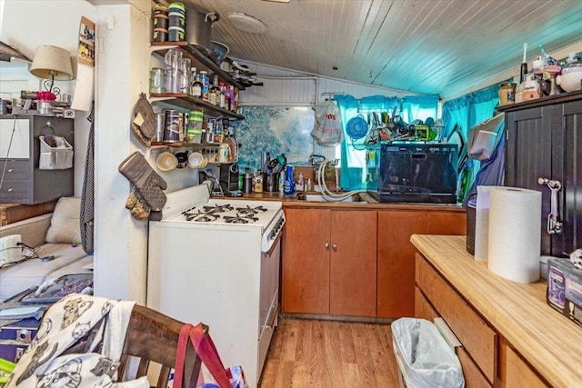 kitchen with vaulted ceiling, white range with gas stovetop, and light wood-type flooring