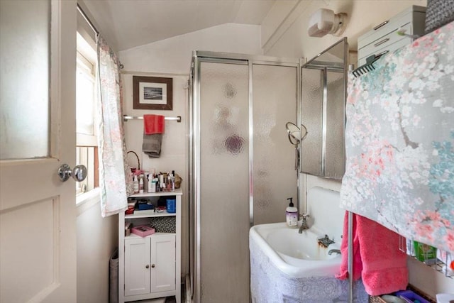 bathroom with lofted ceiling, an enclosed shower, and sink