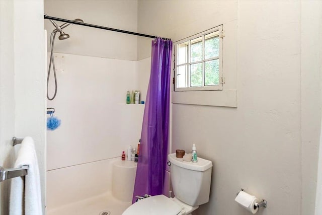 bathroom featuring toilet and walk in shower