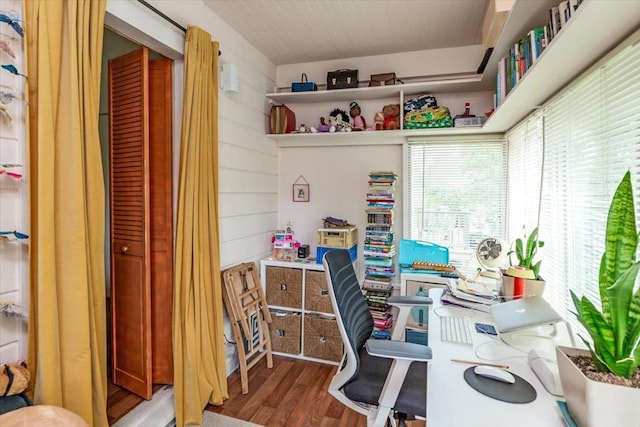 office area featuring hardwood / wood-style floors and wooden walls