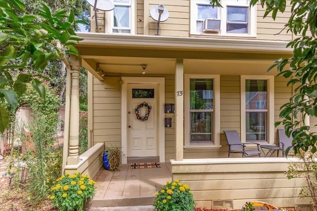 entrance to property with cooling unit and covered porch