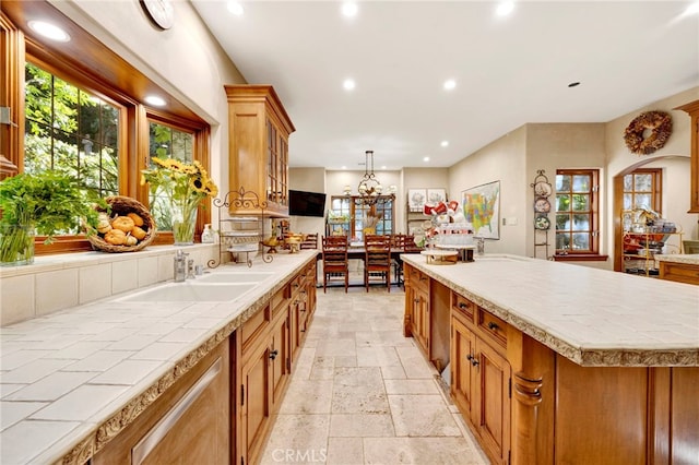 kitchen with sink, a center island, pendant lighting, and a notable chandelier