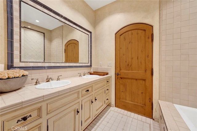 bathroom with tile patterned floors, vanity, and a bath