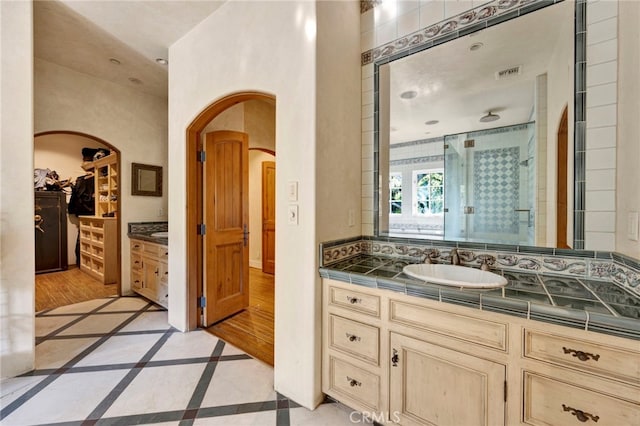 bathroom featuring decorative backsplash, a shower with door, vanity, and hardwood / wood-style flooring