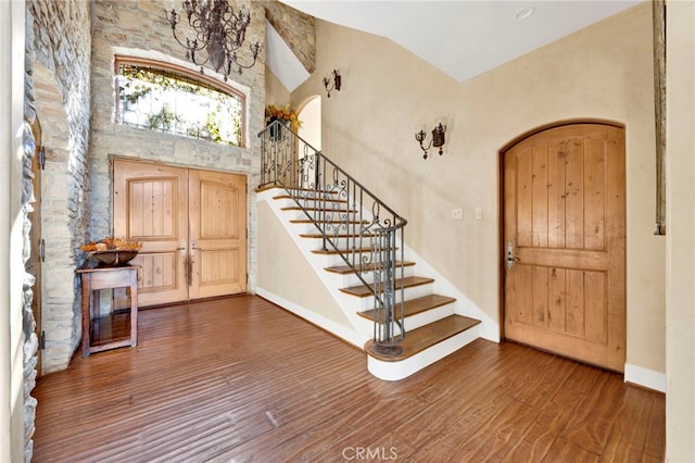 entrance foyer featuring high vaulted ceiling and dark wood-type flooring