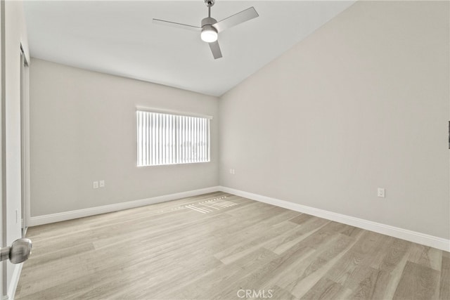 empty room featuring light wood-style floors, lofted ceiling, ceiling fan, and baseboards