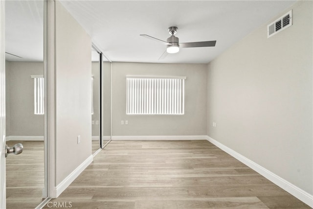 unfurnished bedroom with visible vents, light wood-style flooring, baseboards, and multiple windows