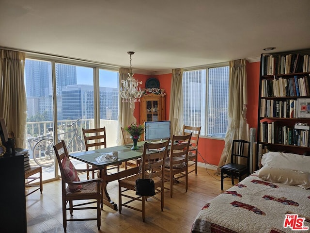 dining room with a notable chandelier, light hardwood / wood-style flooring, plenty of natural light, and ornamental molding