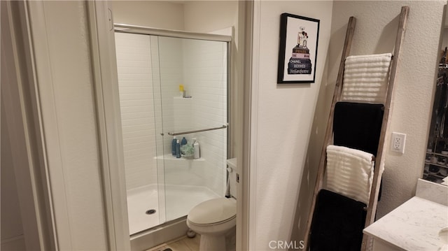 bathroom featuring vanity, toilet, and an enclosed shower