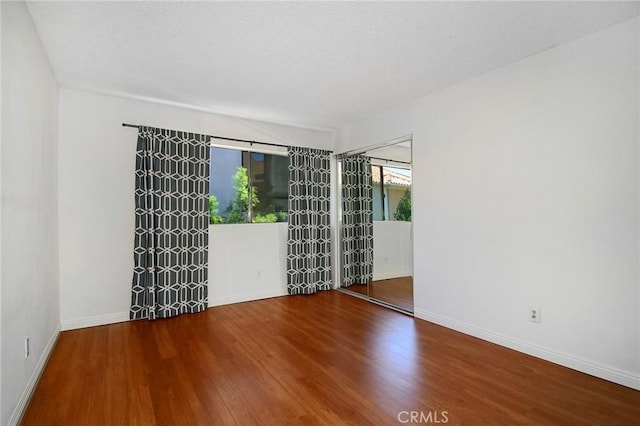 spare room featuring wood-type flooring and a textured ceiling