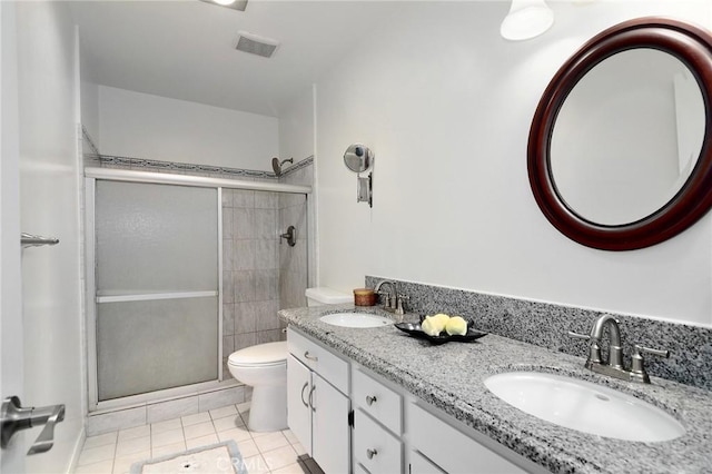 bathroom featuring tile patterned floors, vanity, toilet, and an enclosed shower